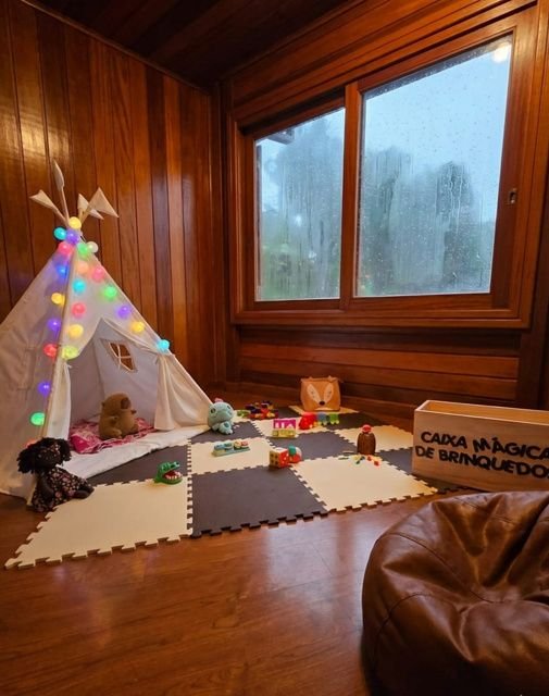 Teepee montado em sala revestida de madeira com tatame