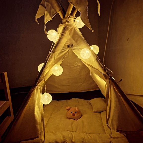 Barraca teepee iluminada por luzes de algodão à noite