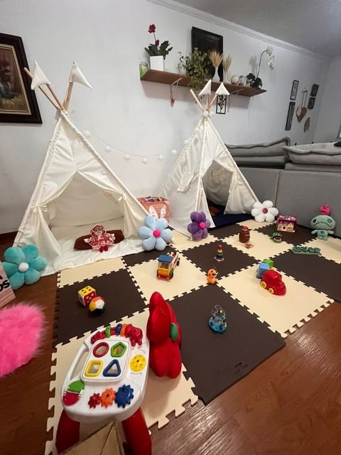Teepee cru com tapete marrom e brinquedos educativos